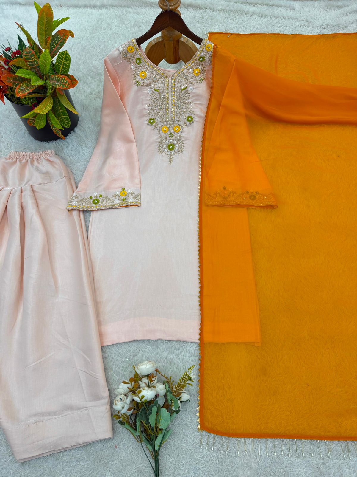 Model in peach salwar suit dancing with dupatta
