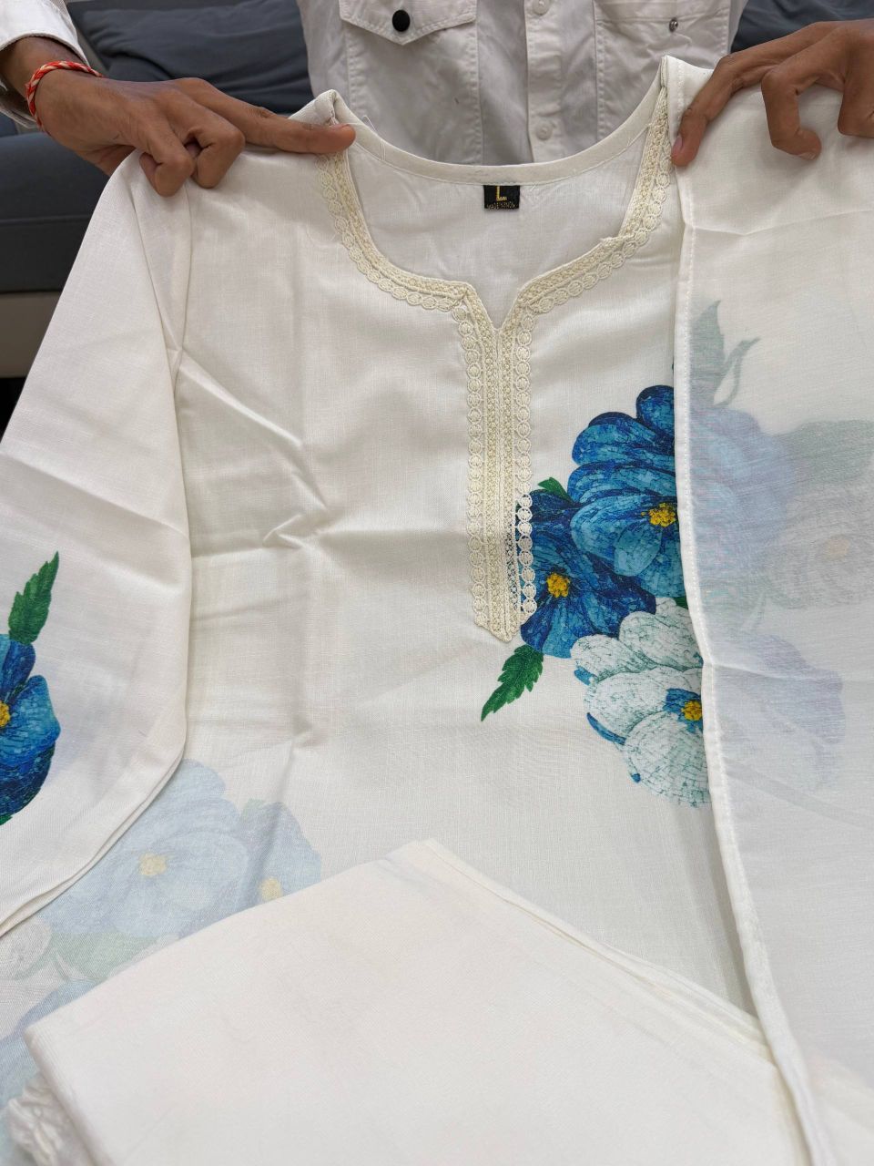 Flat lay of cream lilan kurta showing lace neckline and floral print detail
