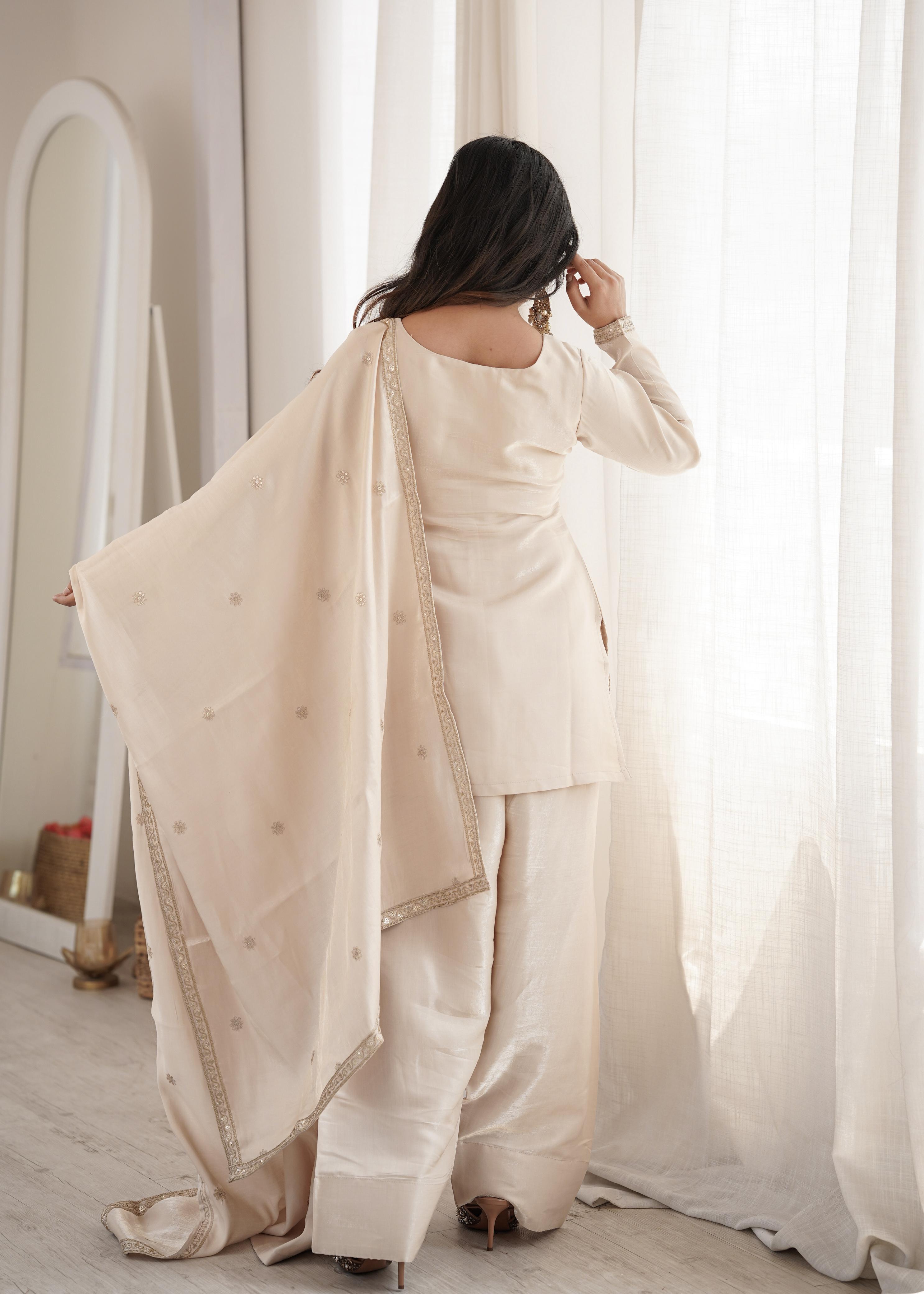 Model smiling in cream sequin embroidered suit set with dupatta