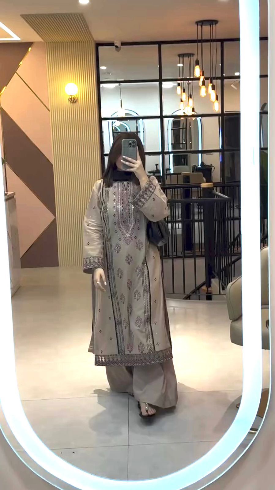 Model in beige faux georgette embroidered suit set taking mirror selfie