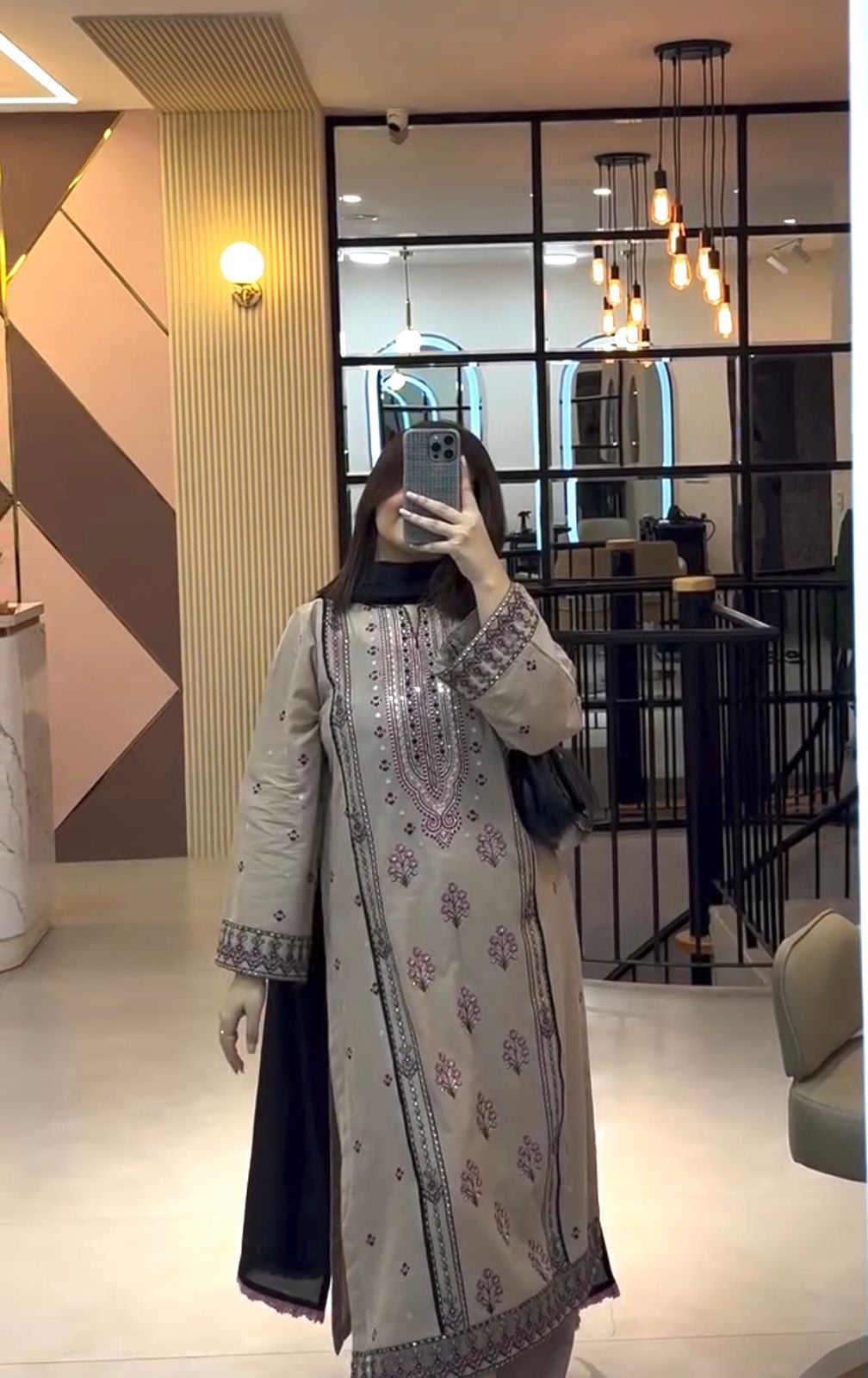 Model posing in beige embroidered kurta palazzo set near staircase
