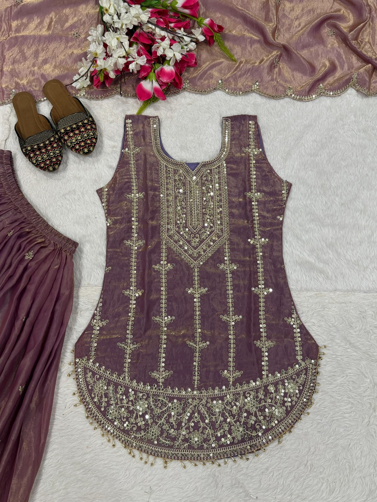 Flat lay of mauve embroidered kurta with scalloped hem and tassel detail