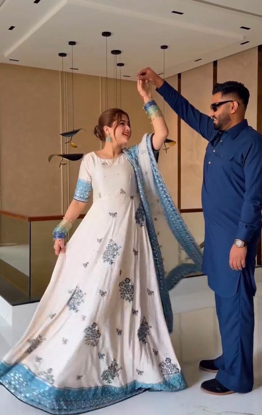 Couple dancing in ivory embroidered gown and navy blue kurta showing gown flair