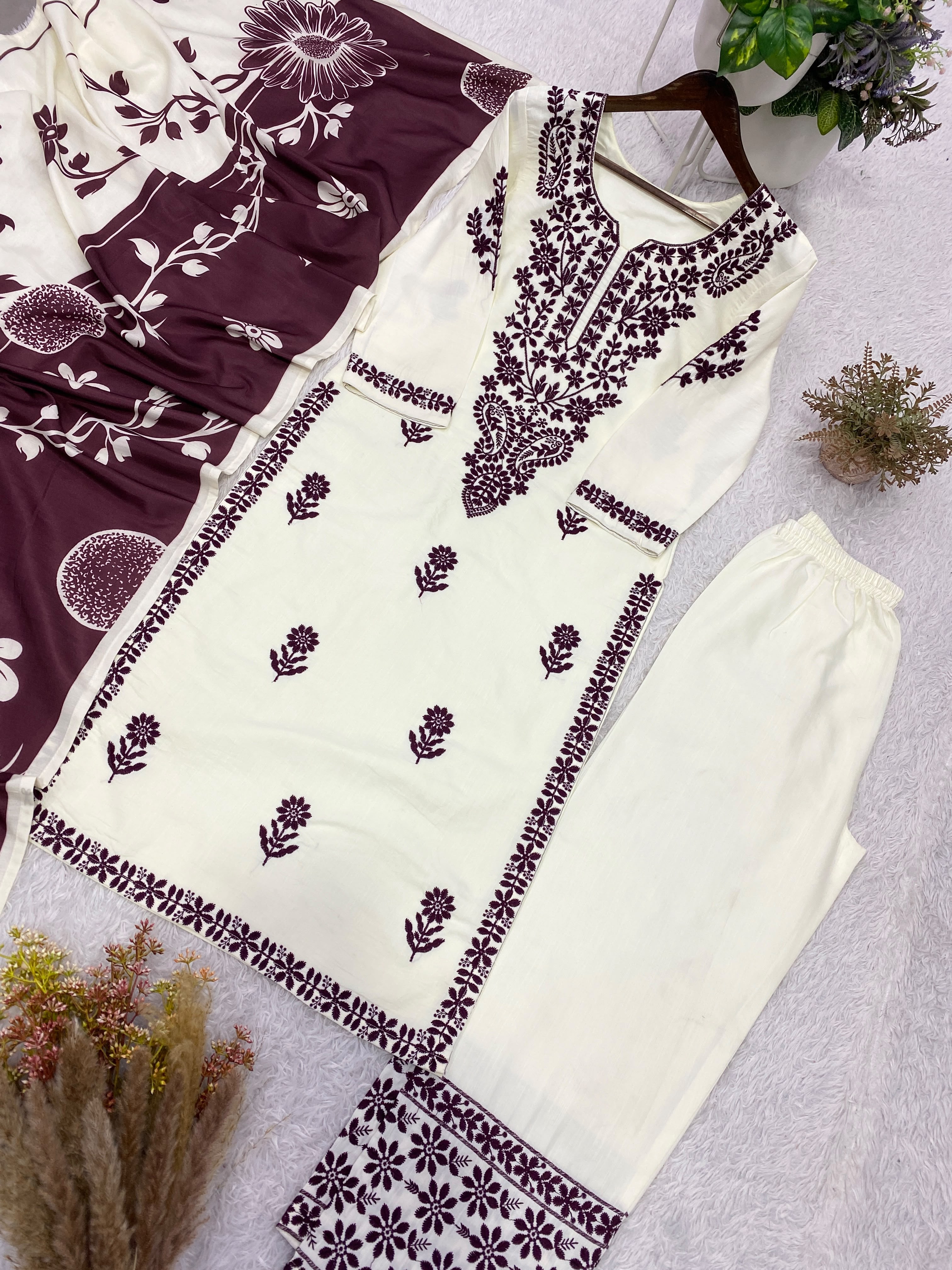 Flat lay of white rayon slub embroidered suit set with black printed dupatta