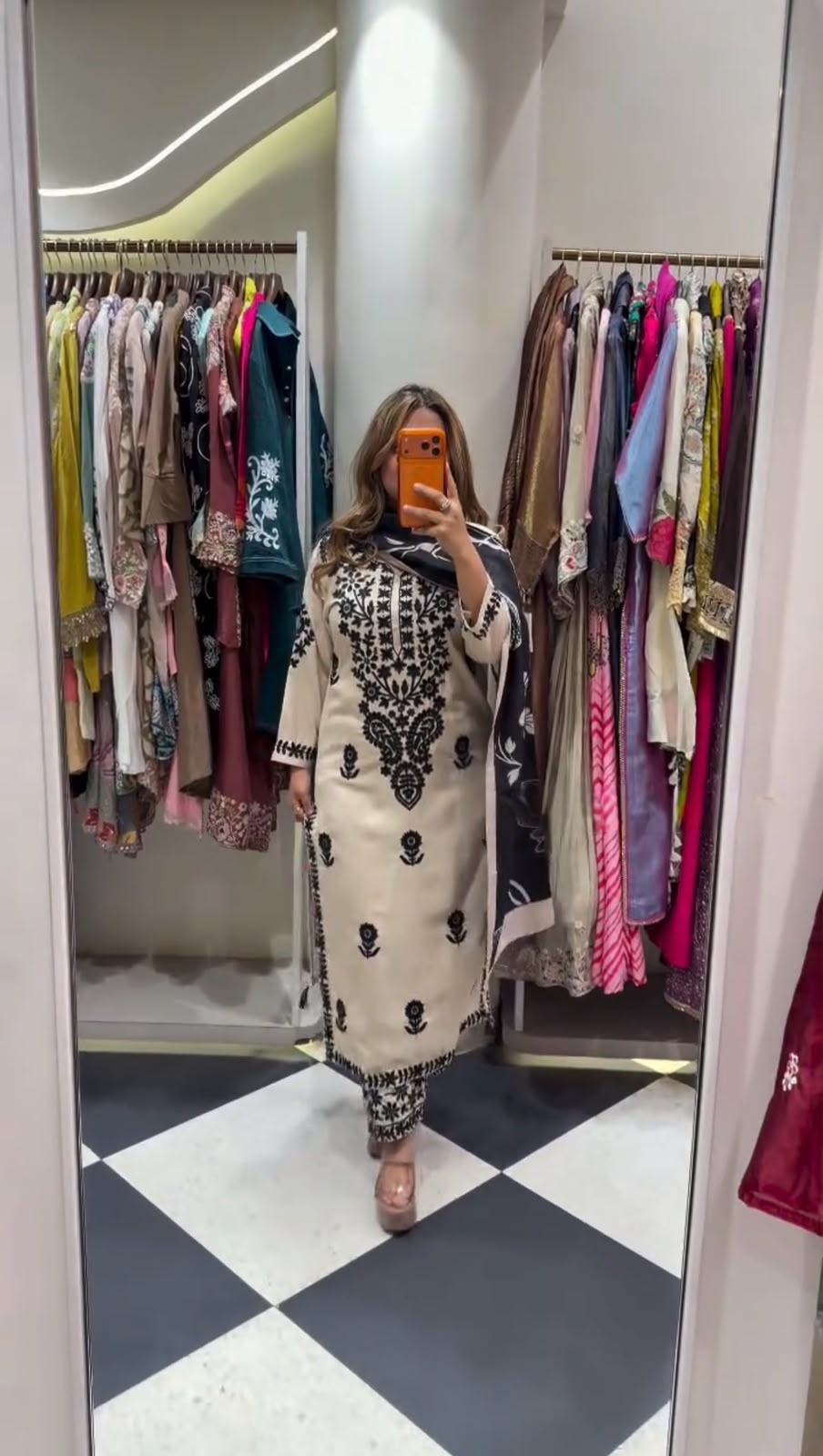 Flat lay of white embroidered kurta with black dupatta and embroidered palazzo