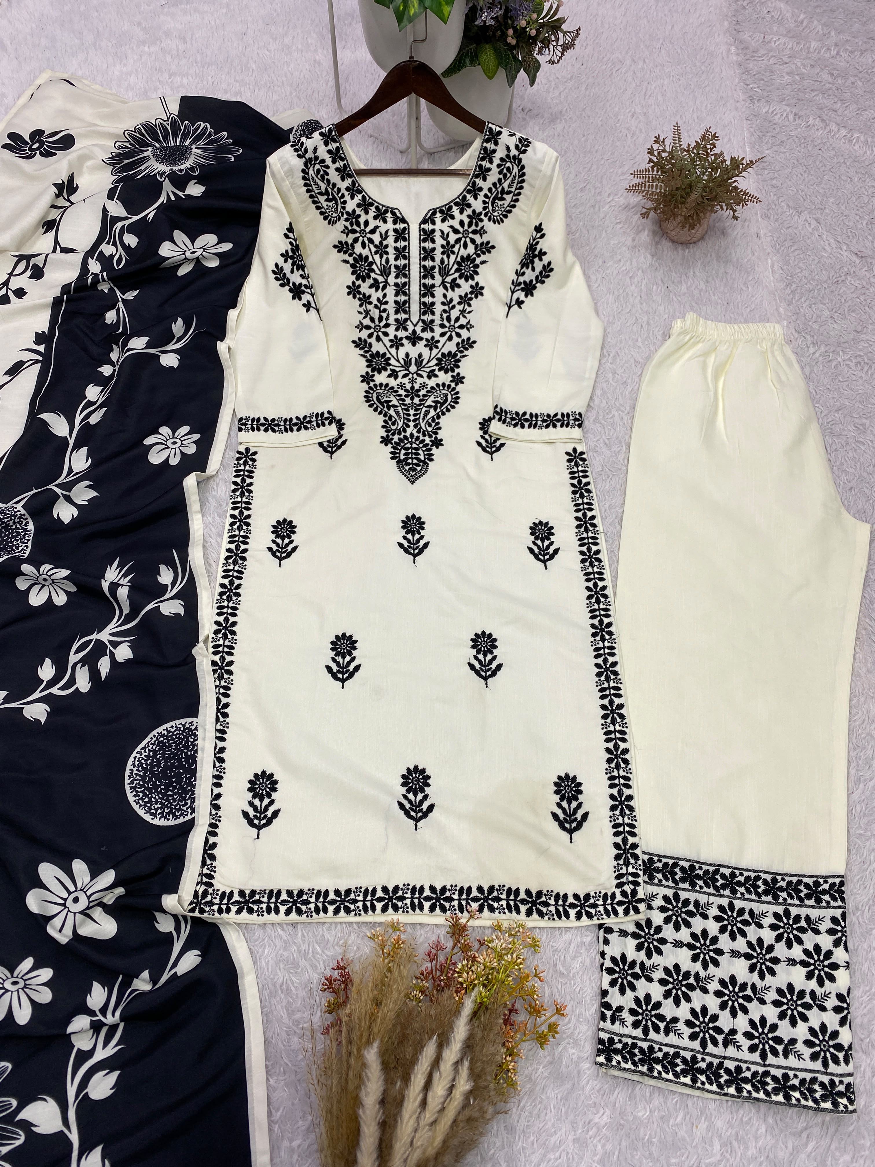 Close-up flat lay of white rayon slub kurta showing wine embroidery yoke and buti motifs