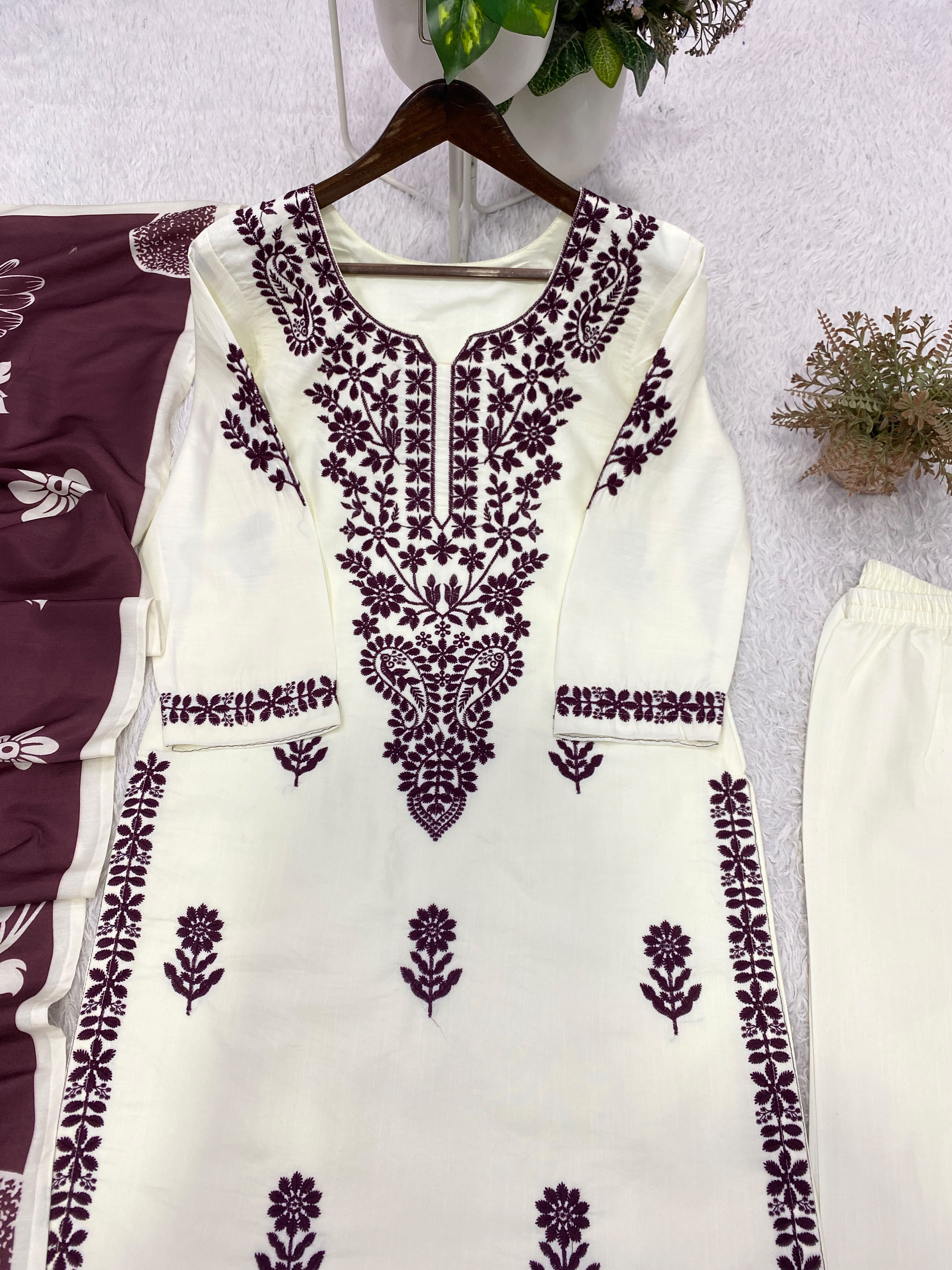 Close-up flat lay of white kurta showing black embroidery V-neck yoke and cuff detail