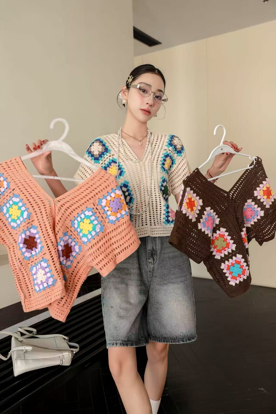 Beautiful Crochet Top - cream granny square V-neck model holding peach and brown variants close up